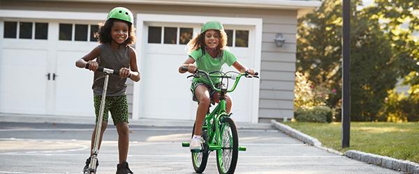 Kids playing in the driveway near garage doors.